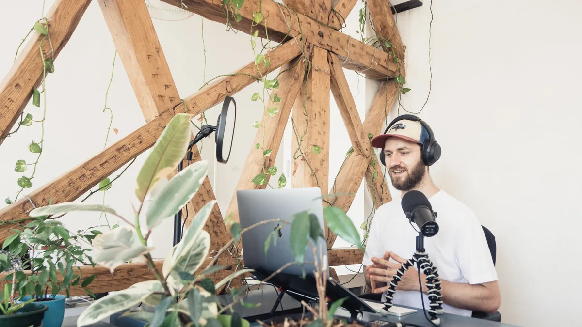 Ev stüdyosunda mikrofon ve dizüstü bilgisayarla podcast kaydeden kişi