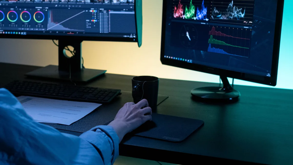 İki monitörde video kurgusu ve renk düzenlemesi yapan editör