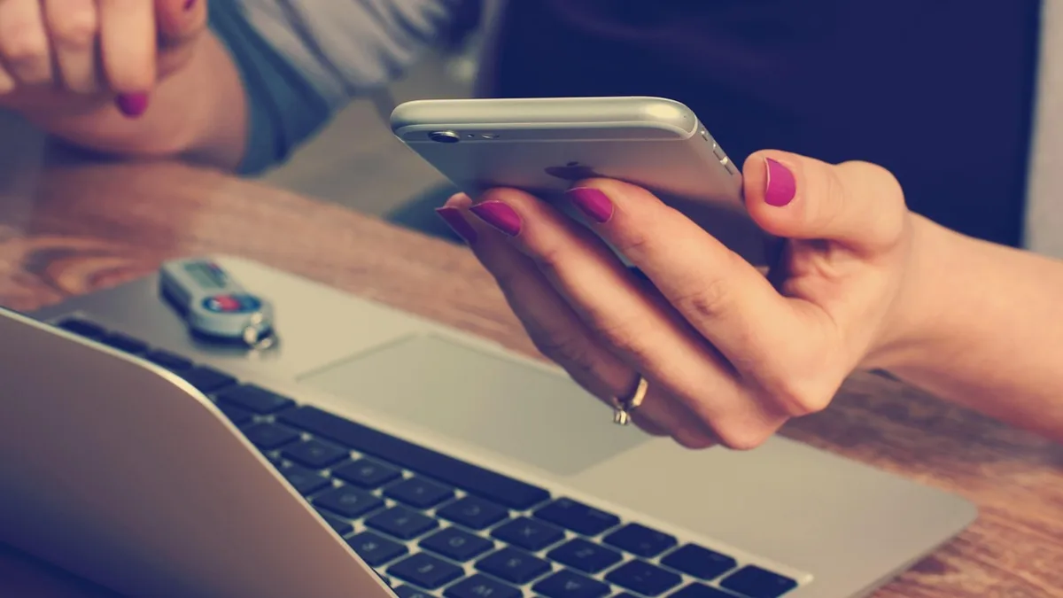 Laptop yanında telefon kullanan içerik üreticisi