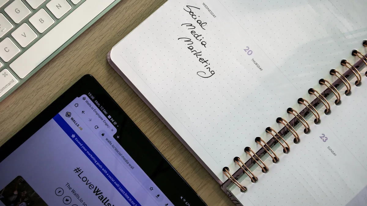 Masa üzerinde tablet, klavye ve sosyal medya planı yazılı defter