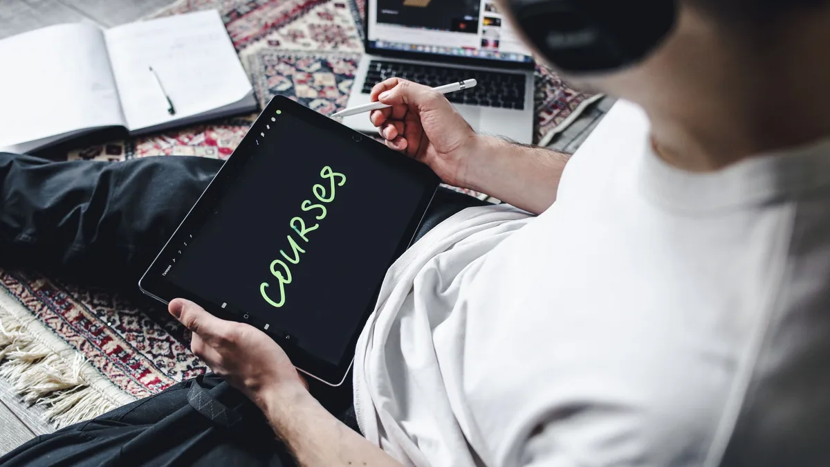 Kulaklık takarak tablette çevrim içi ders izleyen kişi