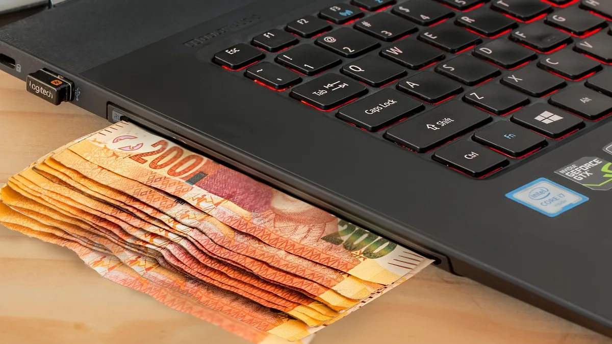 Masa üzerinde dizüstü bilgisayar yanında banknotlar