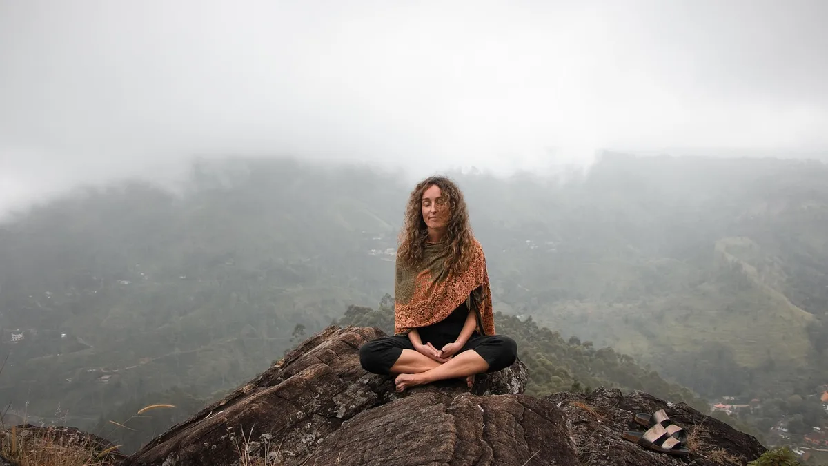 Açık havada manzaraya karşı meditasyon yapan kişi