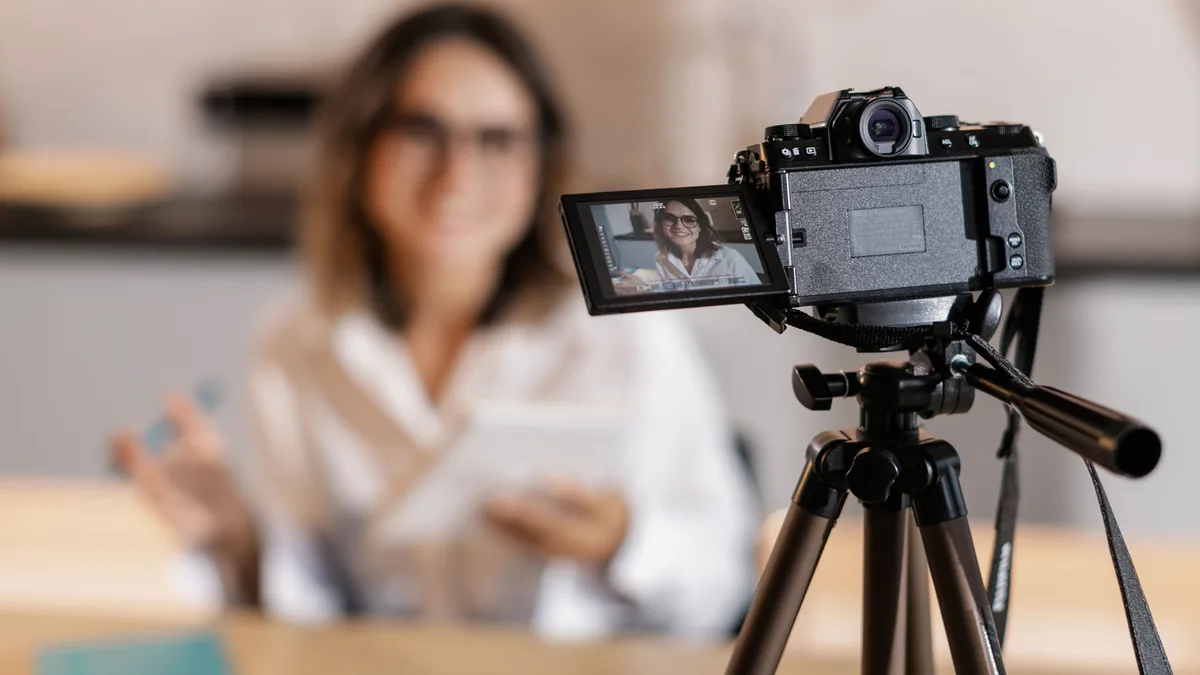 Kamera karşısında not defterini tutarak video çeken içerik üreticisi