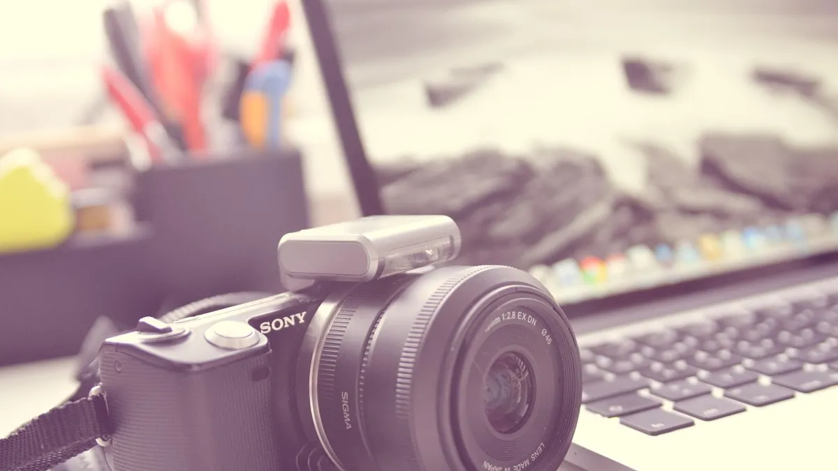 Dizüstü bilgisayar yanında duran fotoğraf makinesi