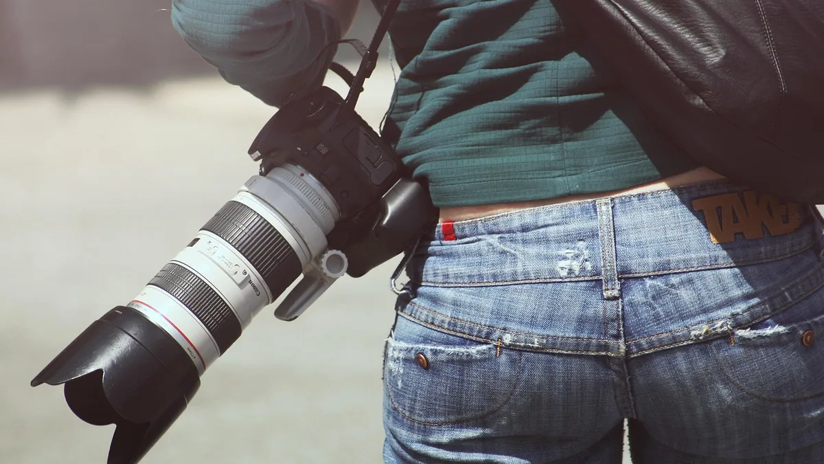Omzunda fotoğraf makinesi taşıyan içerik üreticisi