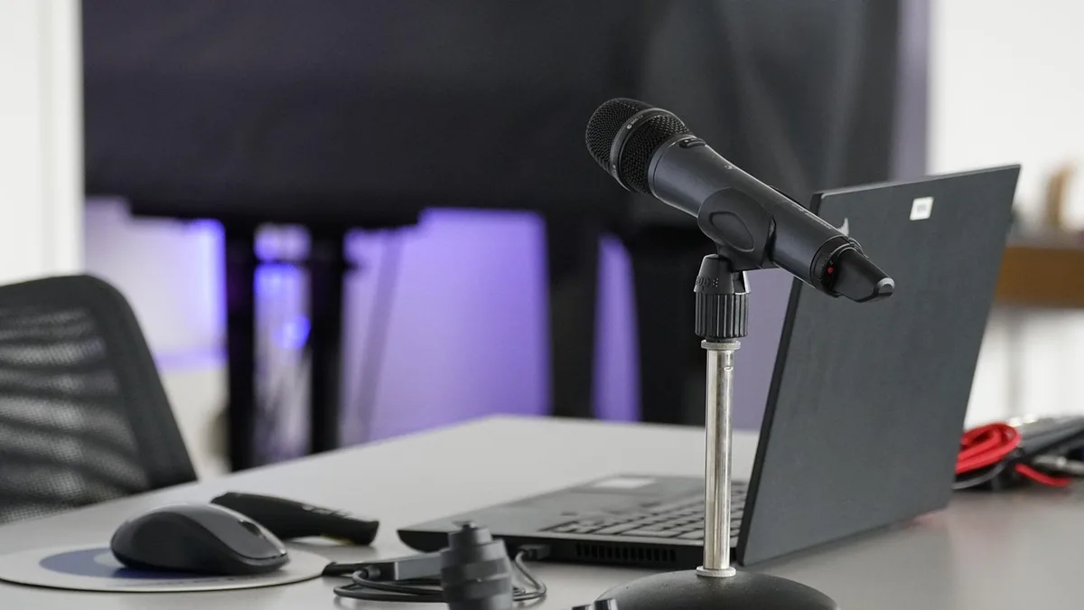 Mikrofon ve dizüstü bilgisayar bulunan yayın masası
