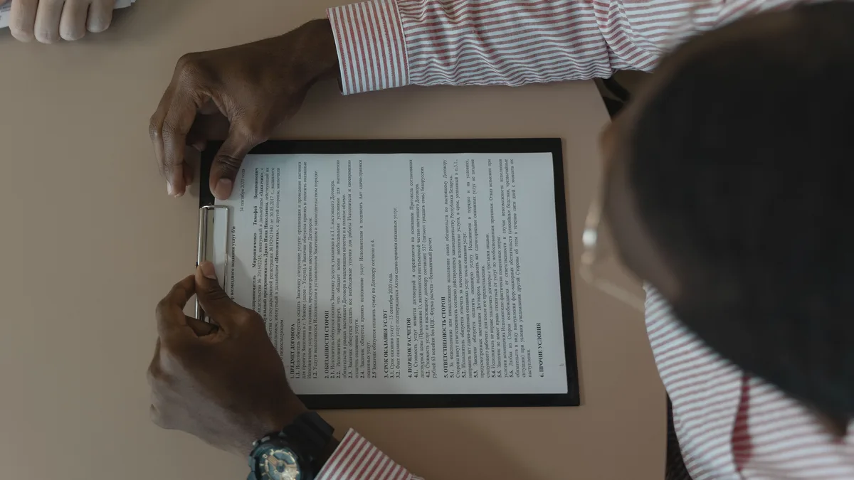 Tablet ekranındaki uzun metni masa başında inceleyen kişi