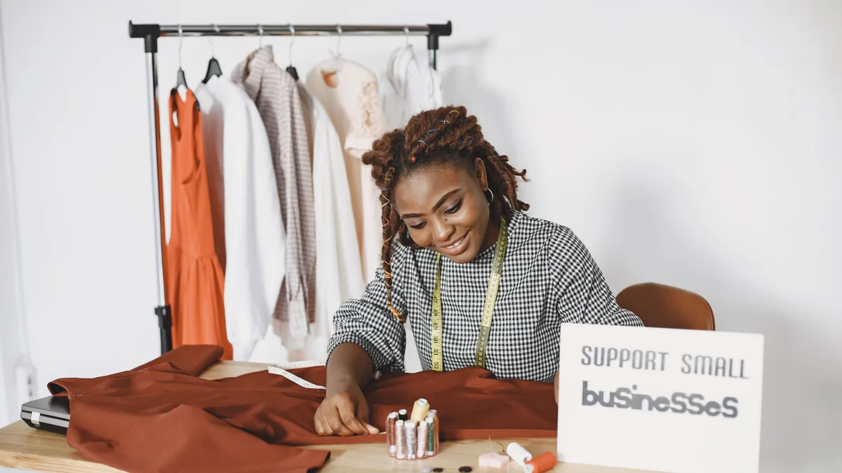 Atölyesinde kumaş üzerinde çalışan moda tasarımcısı