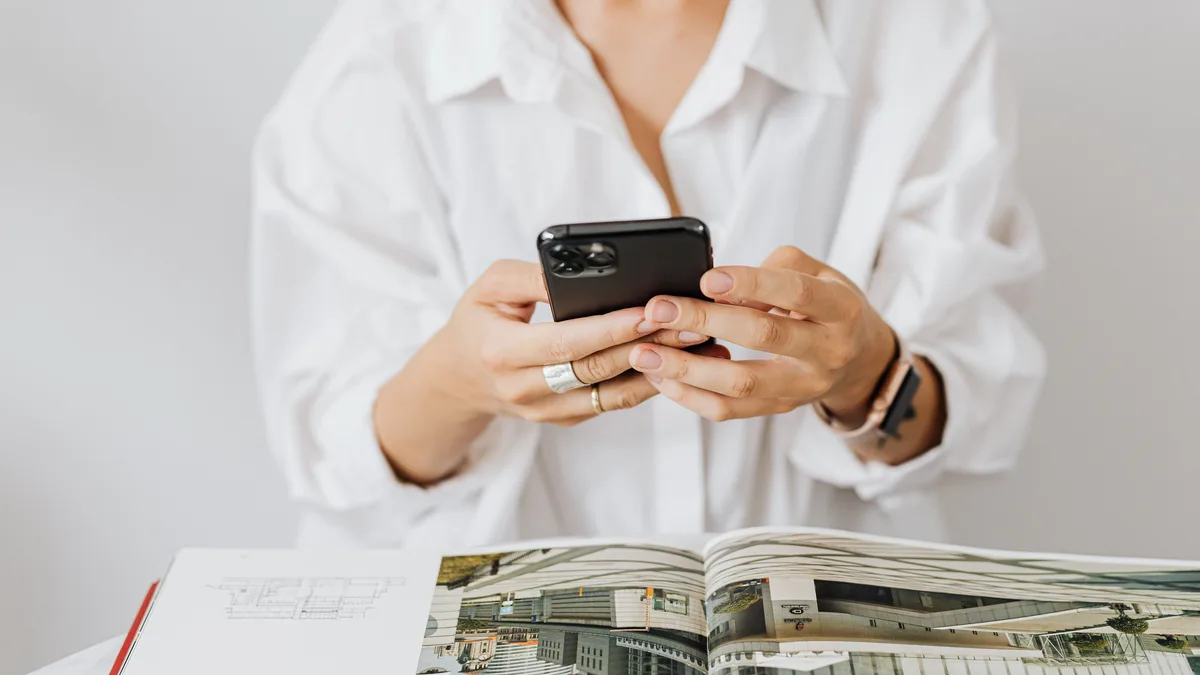 Siyah cep telefonu kullanan beyaz gömlekli kişi
