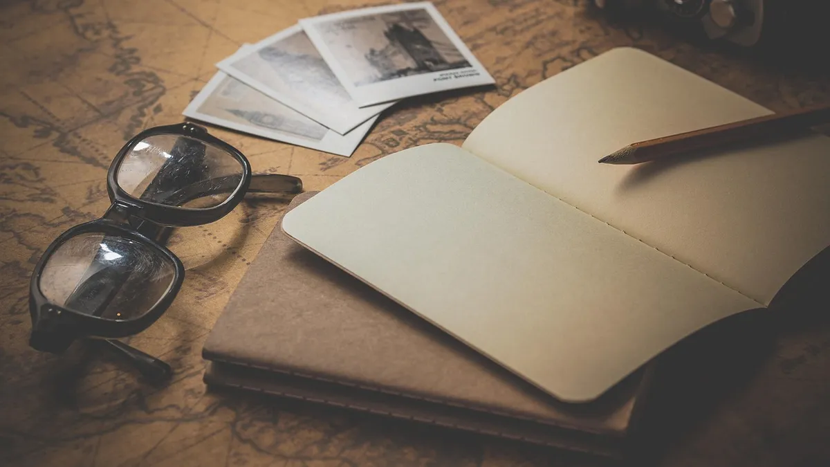 Defter, gözlük ve kalem bulunan çalışma masası