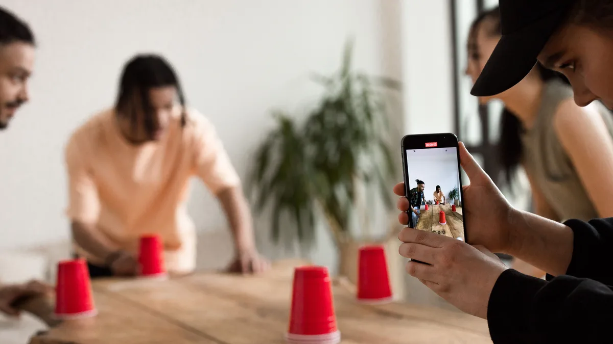 Masa üzerinde telefonla arkadaşlarının videosunu çeken kişi