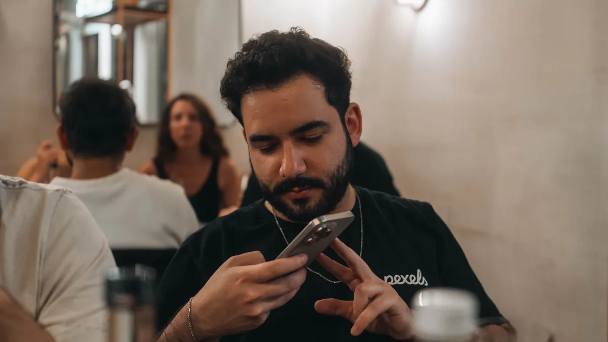 Kafede telefon ekranına bakan kişi