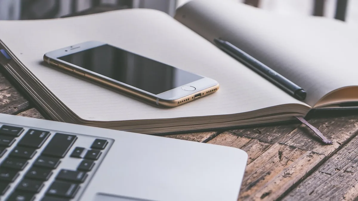 Telefon ve dizüstü bilgisayar bulunan çalışma masası