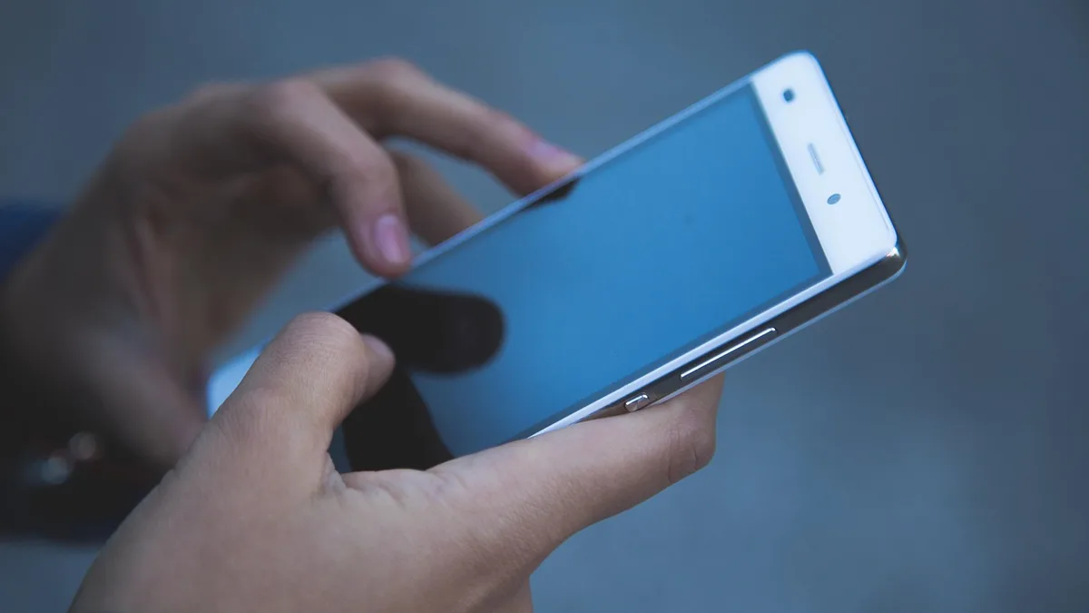 Elinde akıllı telefon tutan kişinin ekrana dokunması
