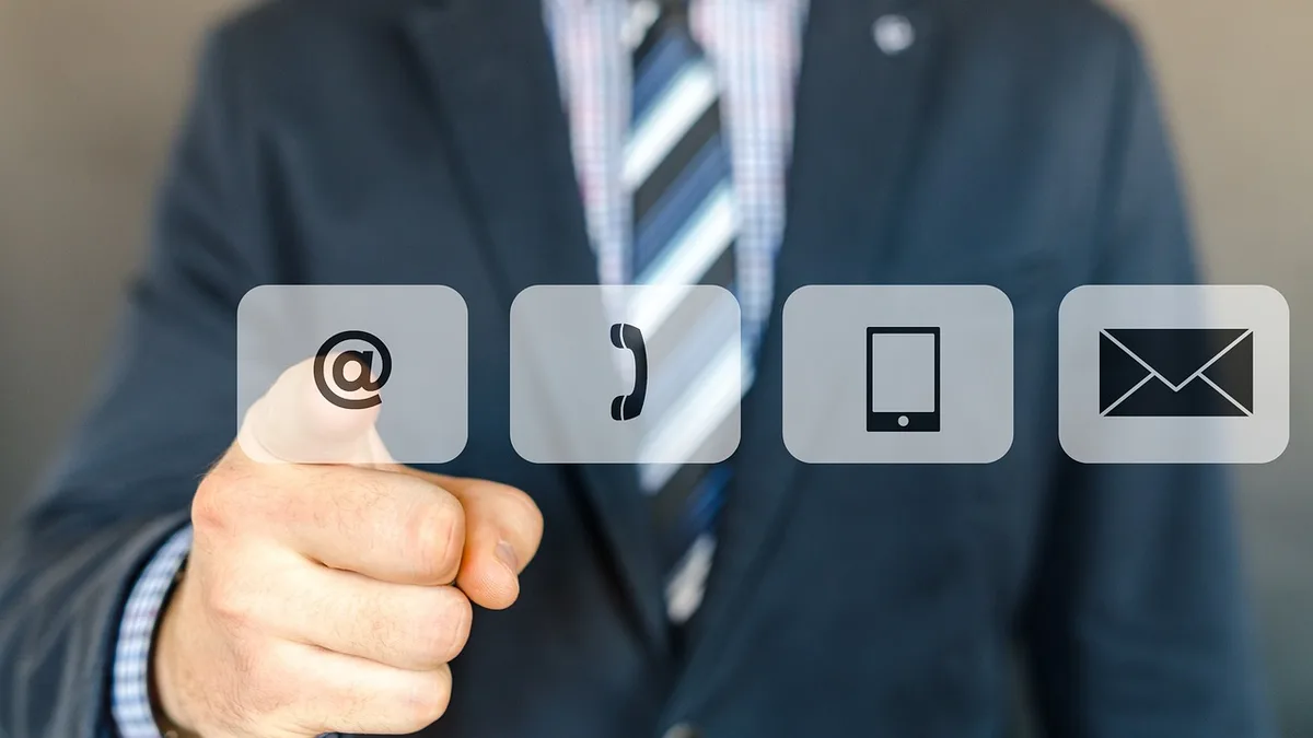 E-posta, telefon ve mobil iletişim simgelerine dokunan takım elbiseli kişi
