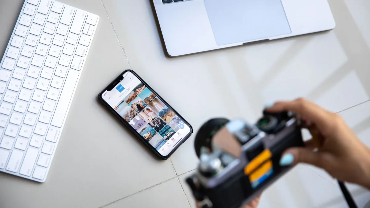 Masa üzerindeki telefon ekranını fotoğraflayan kişi