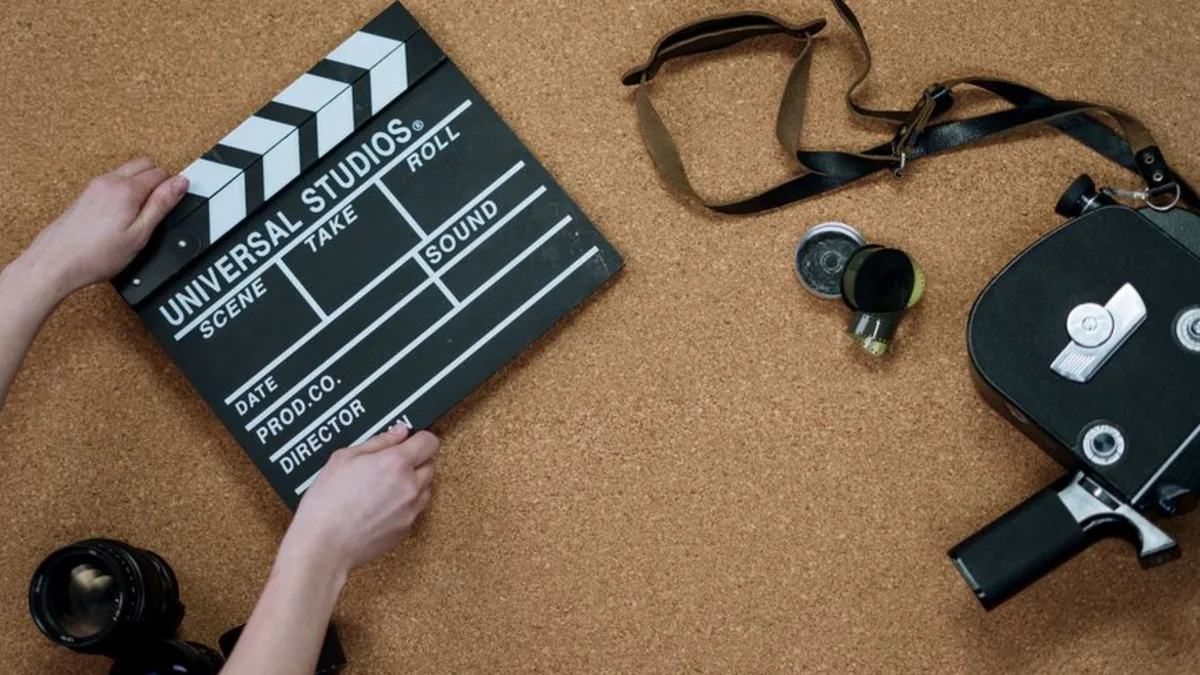 Masa üzerinde klaket, film makarası ve kulaklıklar