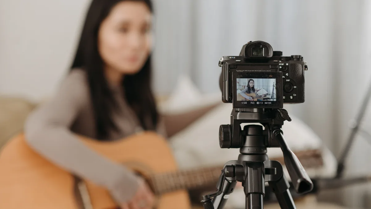 Kamera karşısında gitar çalıp kayıt yapan kadın