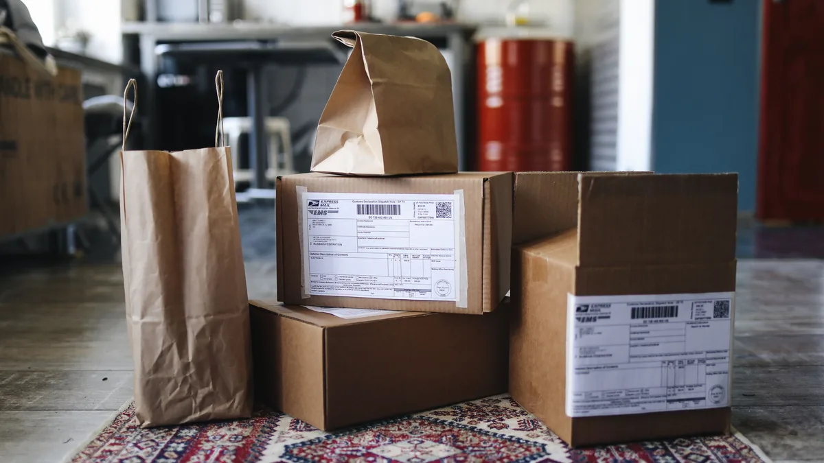 Halı üzerinde karton kutular, kâğıt paketler ve gönderi etiketleri