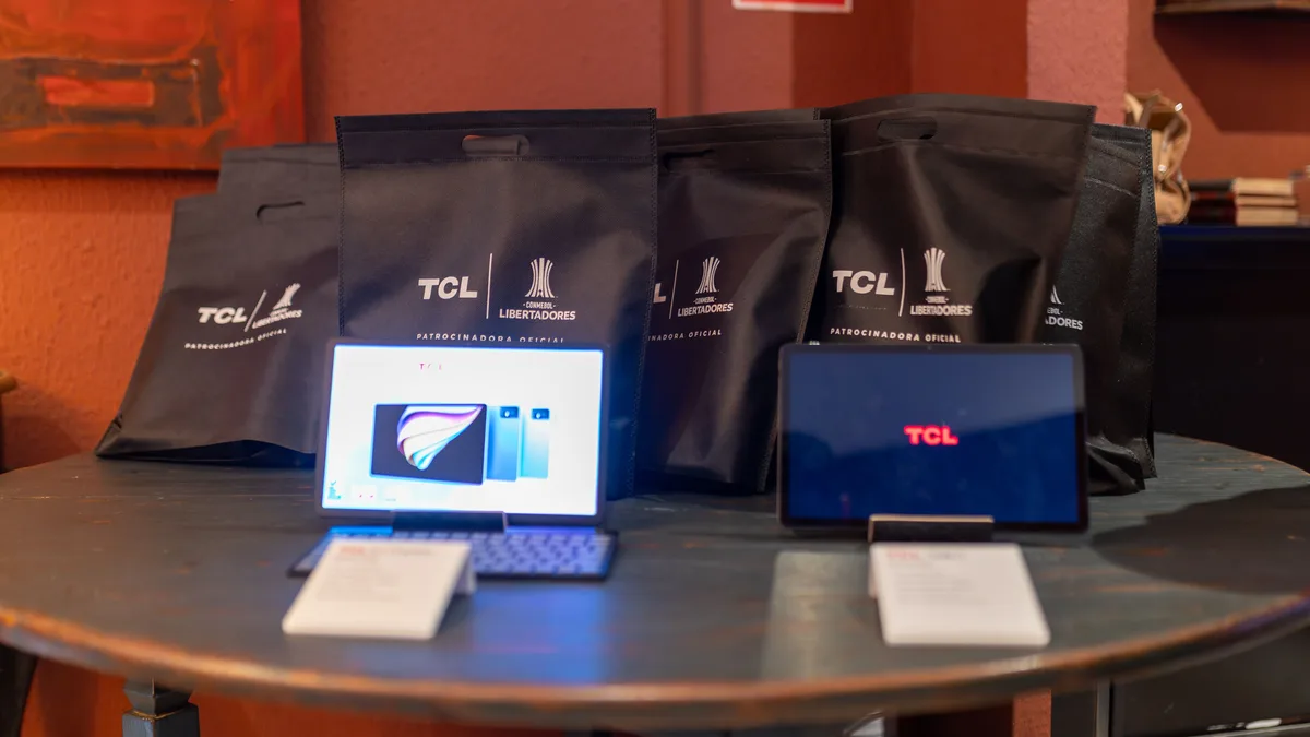 Etkinlik masasında dizüstü bilgisayarlar, tabletler ve hediye çantaları