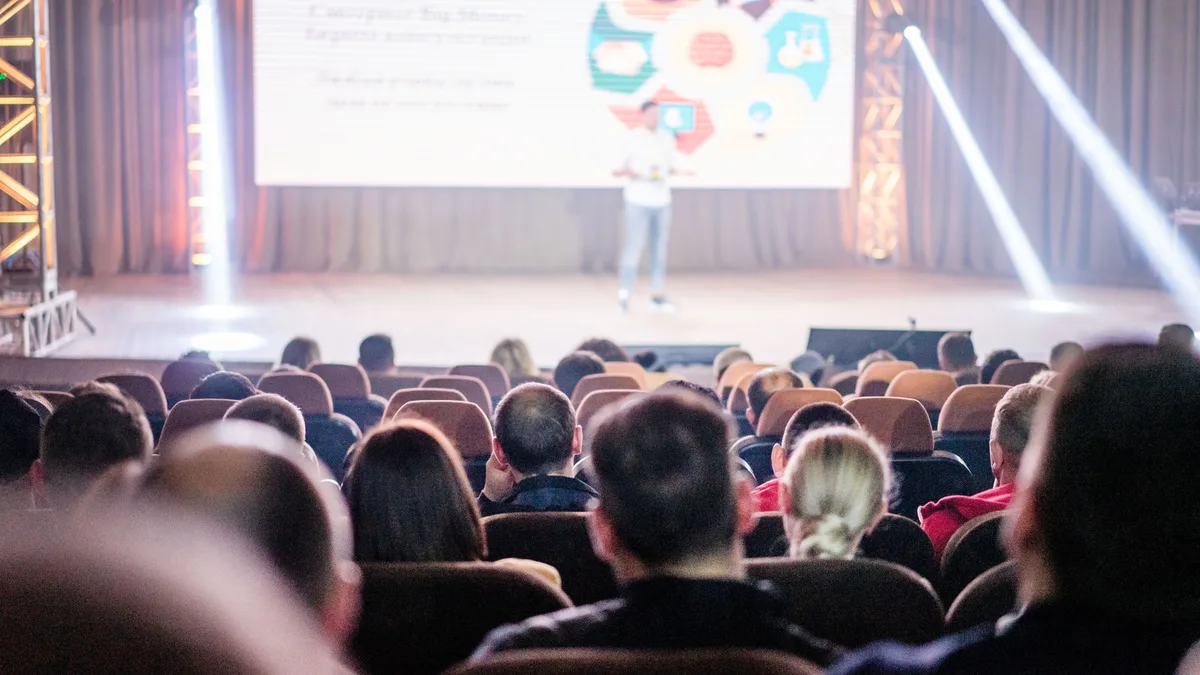 Sahnede sunumu izleyen konferans katılımcıları