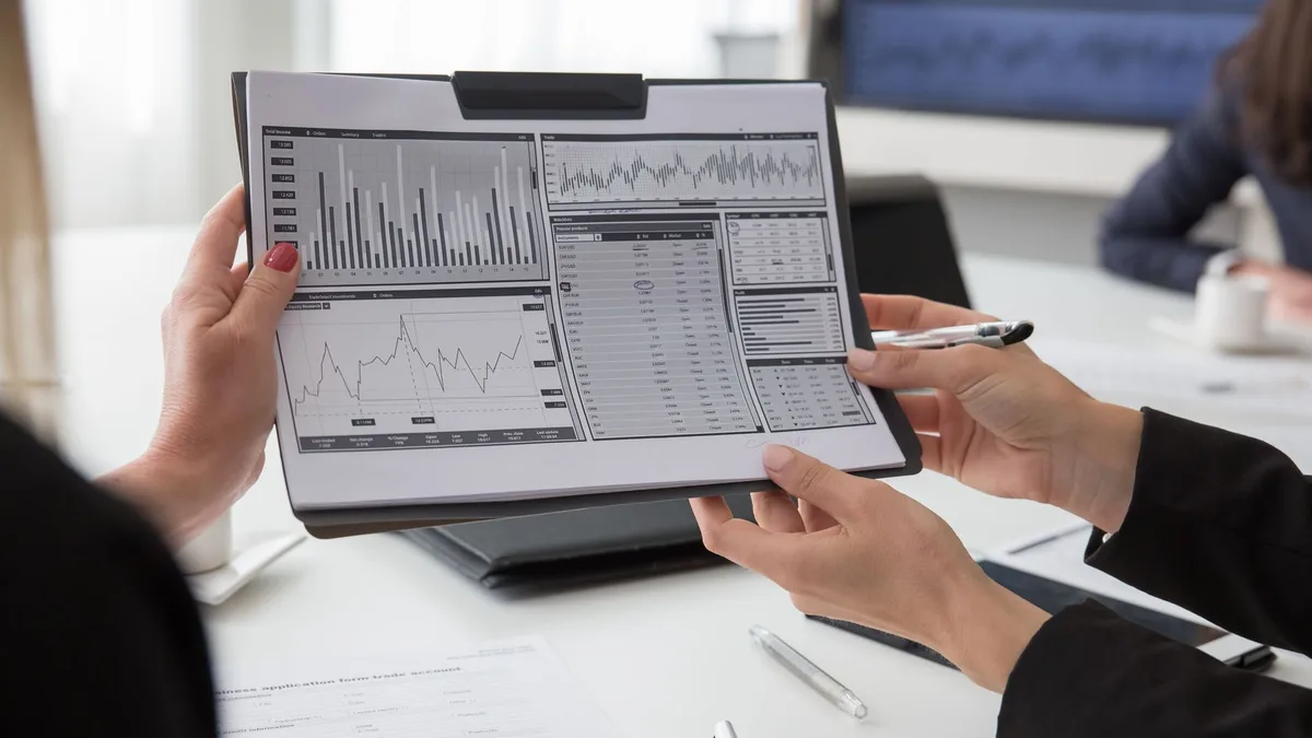 Tablet ekranındaki grafik ve basılı raporu birlikte inceleyen profesyoneller
