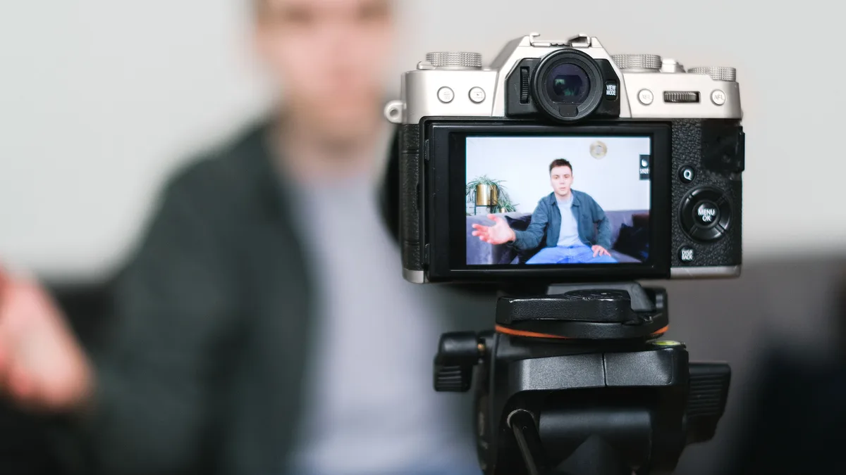 Kamera ve video ekipmanlarının önünde kurgu paneli bulunan çalışma alanı