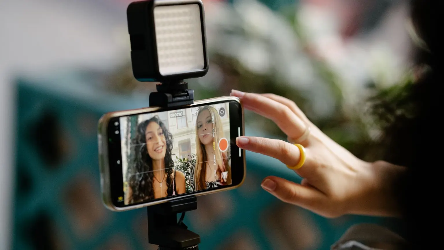 Telefon tripodunda bir kişiyle video görüşmesi görüntüsü yer alıyor.