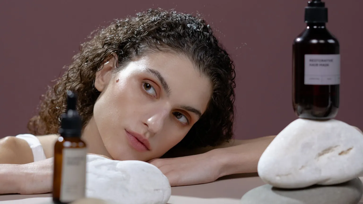 Cilt bakım ürünleri ve doğal taşlar yanında bir model görülüyor.