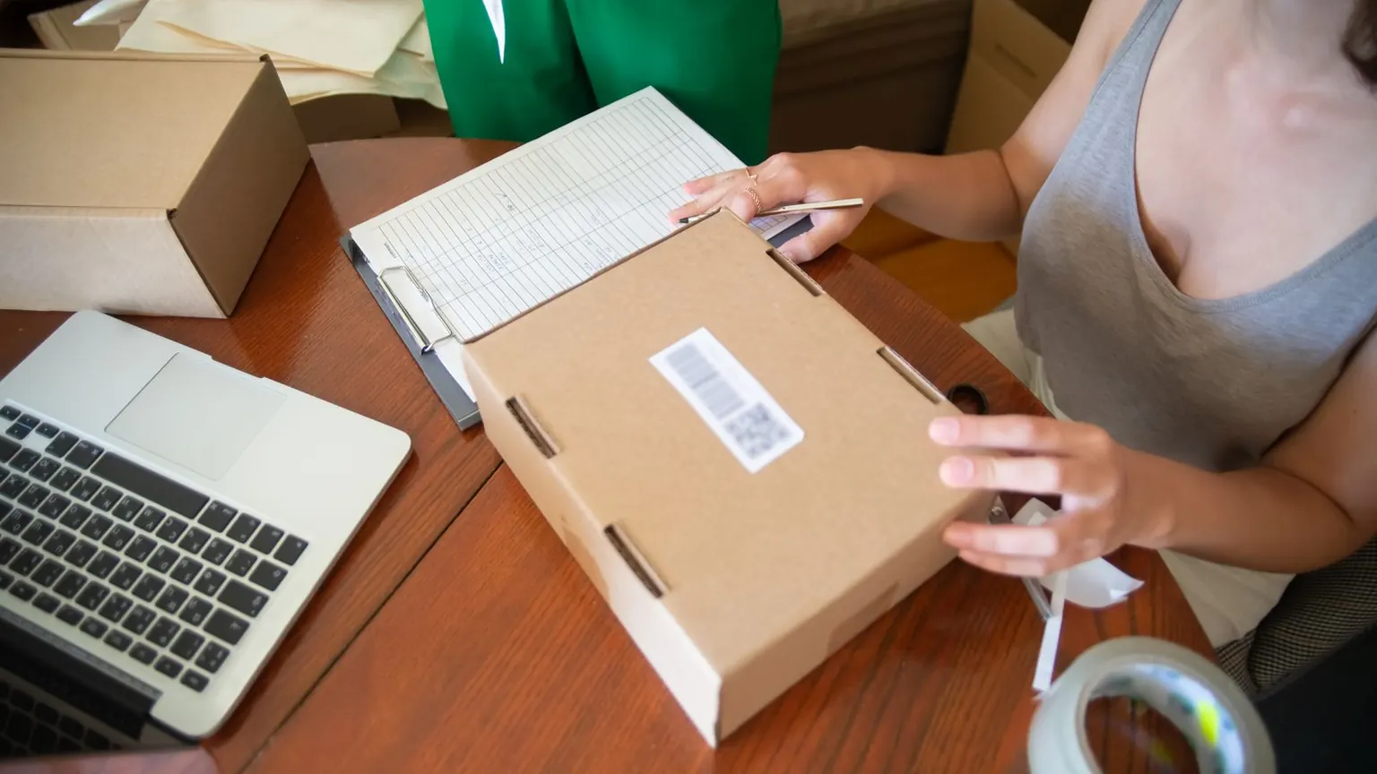 İki kişi küçük işletme paketlerini masada hazırlıyor.