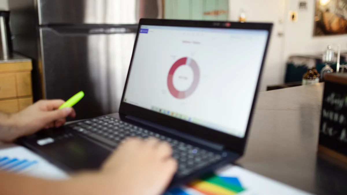 Dizüstü bilgisayarda halka grafik inceleyen kişi