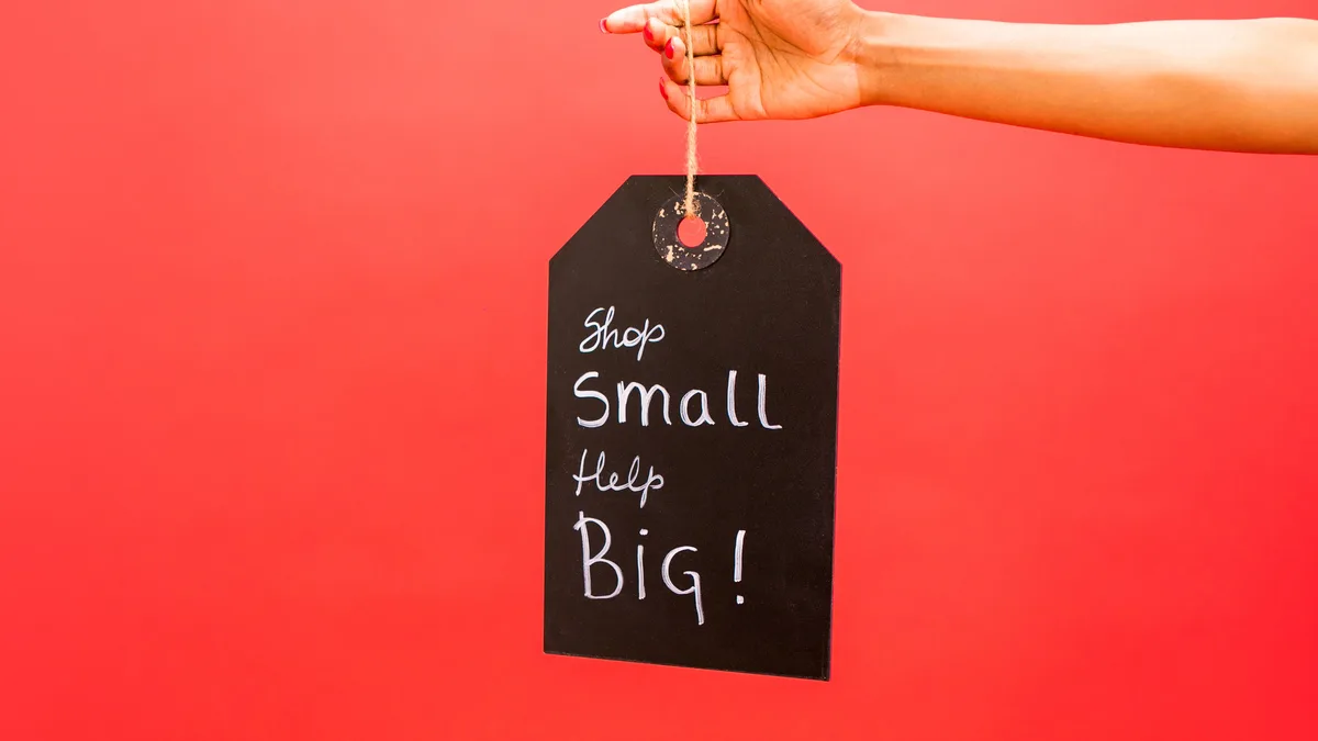 Kırmızı zeminde Shop Small Help Big yazılı siyah etiket