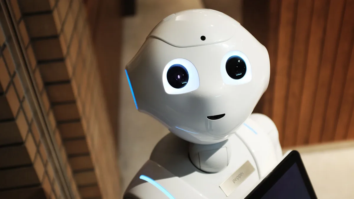 Ahşap zeminde tablet taşıyan beyaz robot