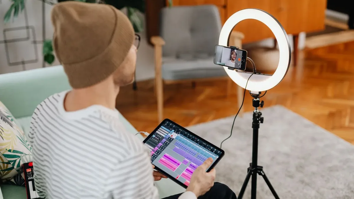 Halka ışık önünde tabletle video kaydeden içerik üreticisi