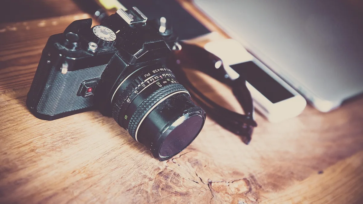 Masa üzerinde fotoğraf makinesi ve akıllı telefon