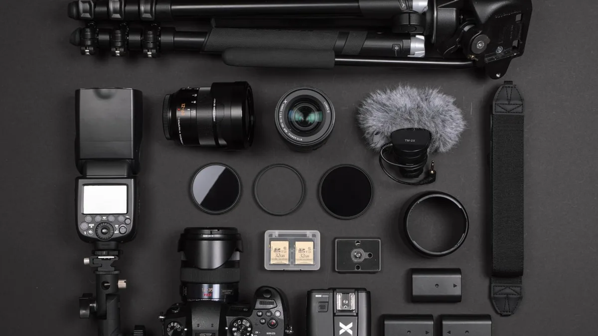 Masa üzerinde fotoğraf makinesi, objektif ve küçük çalışma araçları