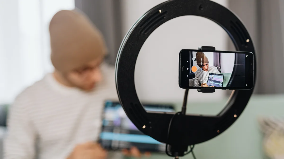 Ring ışığı içinden telefonla video kaydı yapan kişi
