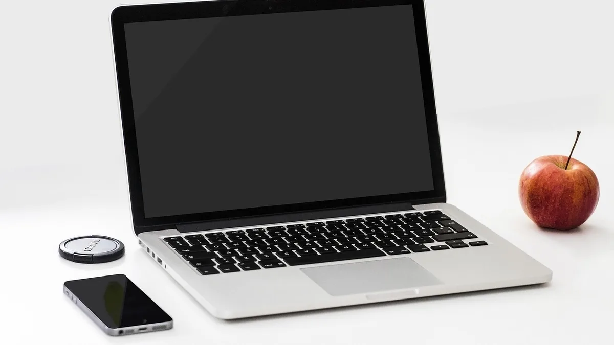 Dizüstü bilgisayar, telefon ve not defteriyle dijital içerik paketi hazırlanan masa