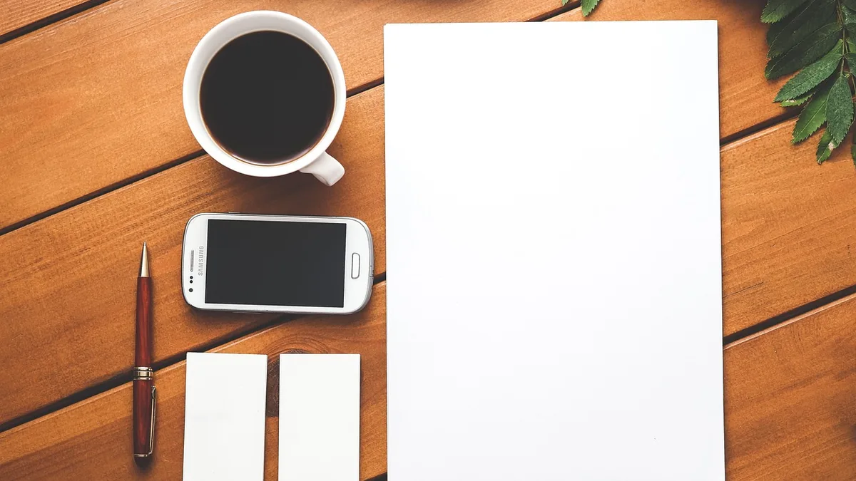 Kahve, telefon ve boş kâğıtlarla kampanya hatalarını gözden geçirmeye uygun masa