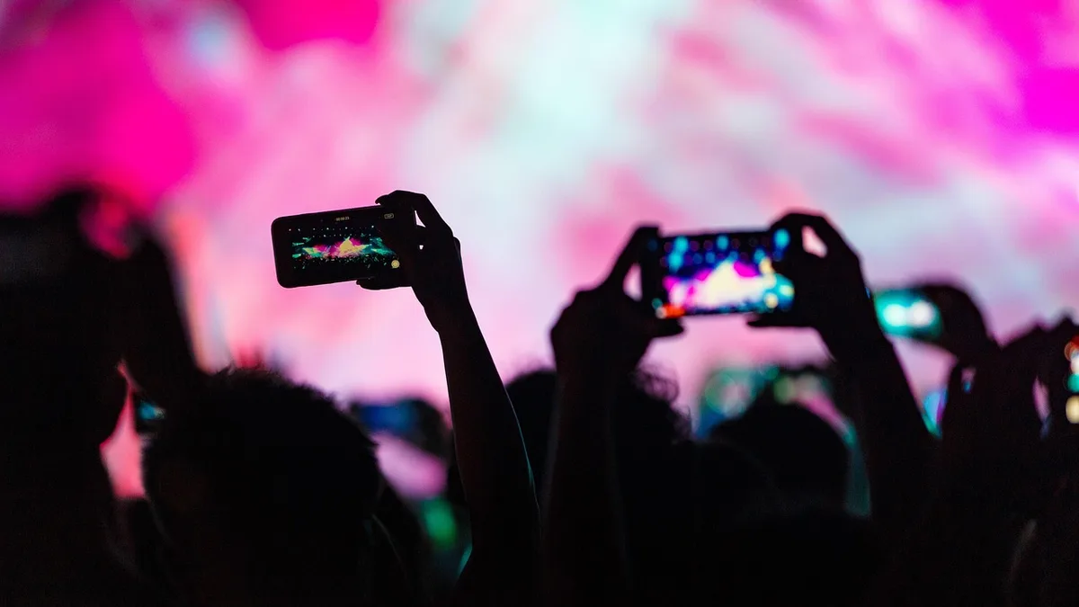 Konserde sahneyi telefonlarıyla kaydeden izleyiciler