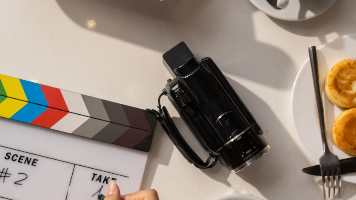 Film klaketi ve kamera yanında sahne planı yazan kişi