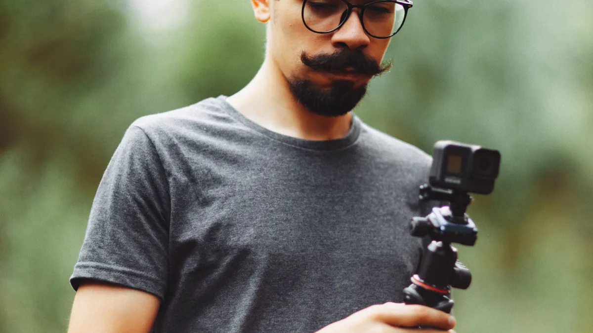 Dış mekânda telefon ve küçük tripodla çekim yapan kişi