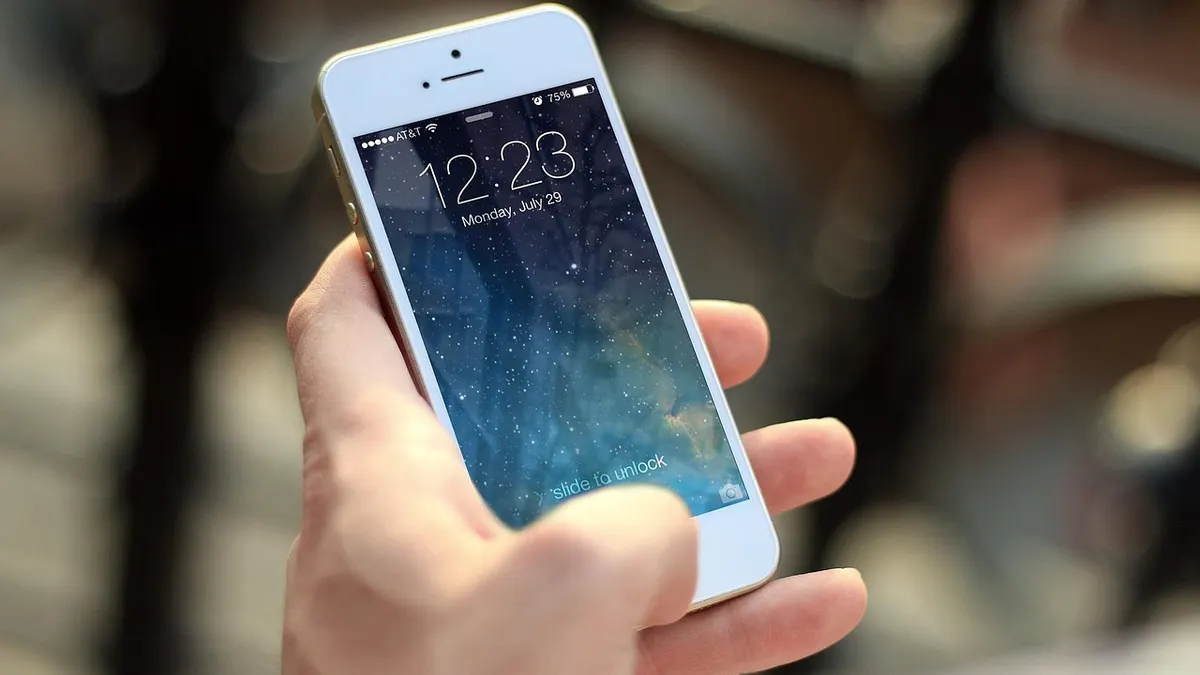 Ekranı açık akıllı telefonu elinde tutan kişi