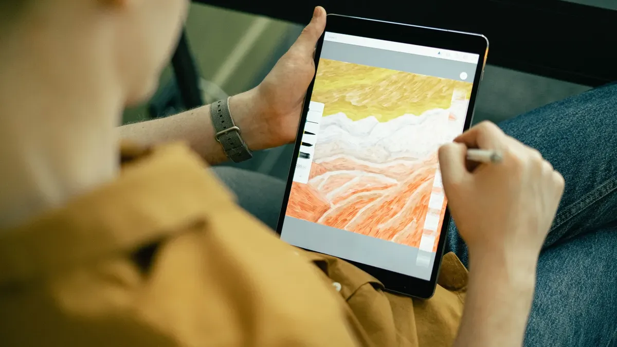 Kalemle tablet üzerinde renkli dijital çizim yapan el