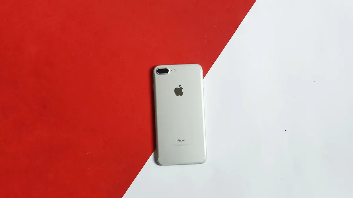 Kırmızı ve beyaz geometrik zeminde üstten çekilmiş akıllı telefon