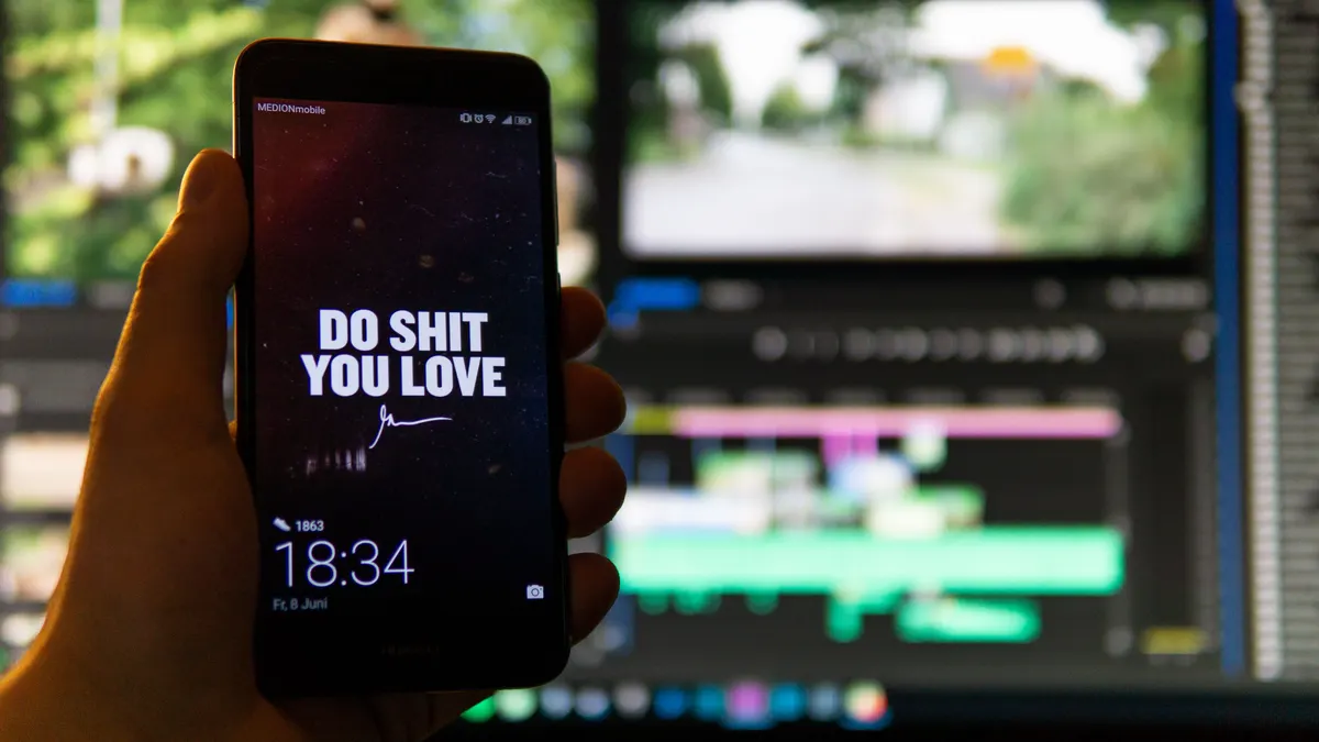 Telefon önünde video kurgu zaman çizelgesi bulunan çalışma masası