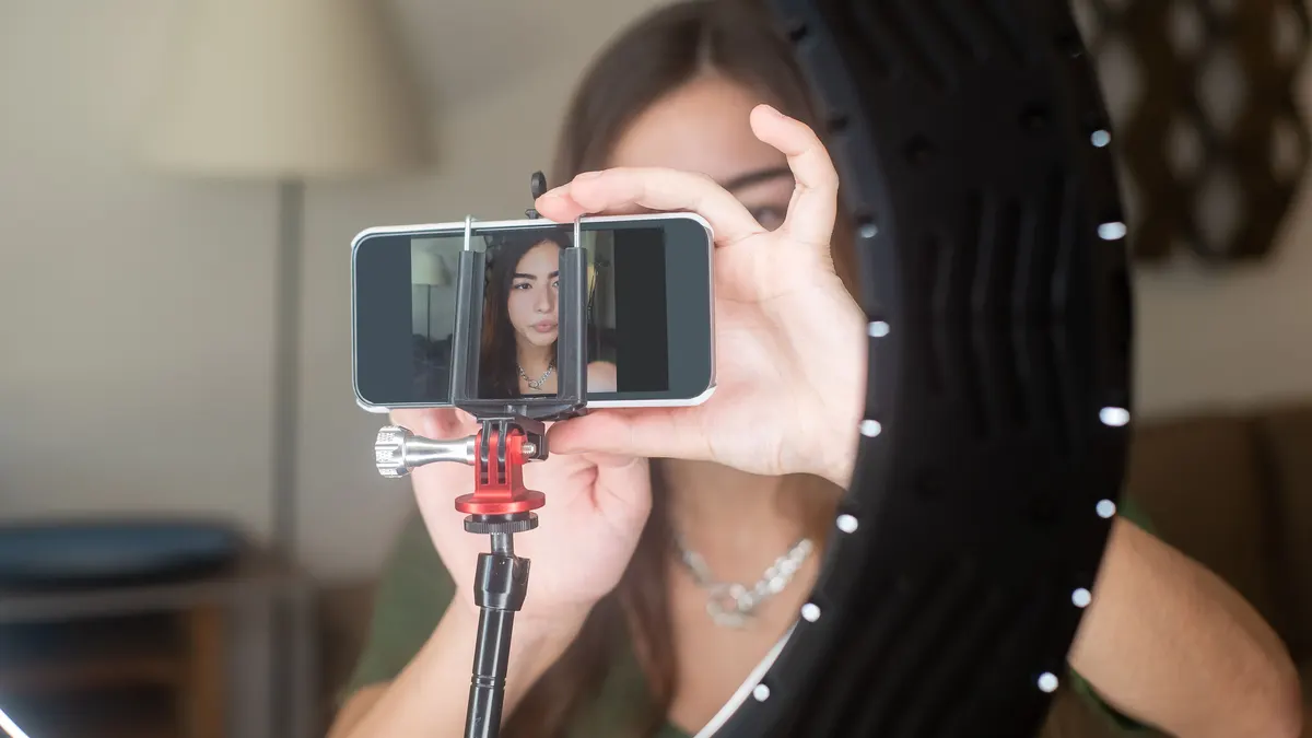 Halka ışığın arkasında telefon kamerasına konuşan kişi