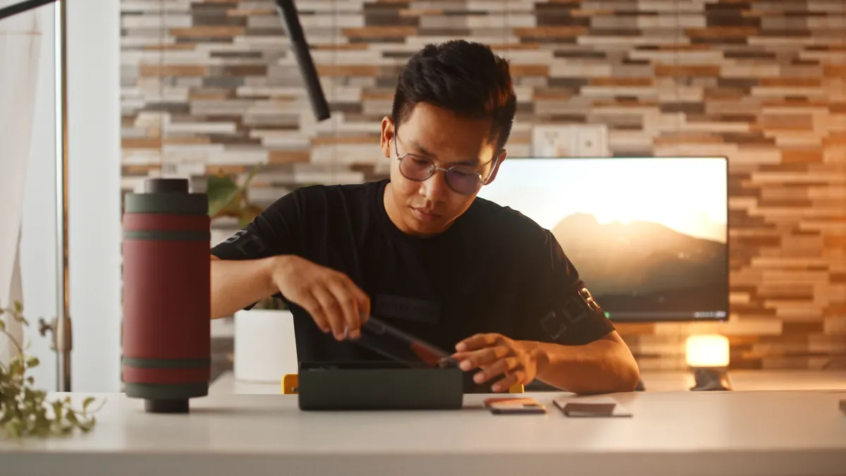 Masa başında telefon kamerasına eğitim videosu çeken kişi