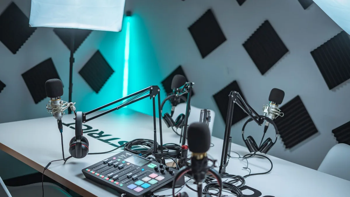 Mikrofonlar, ses mikseri ve sandalyeler bulunan boş podcast stüdyosu